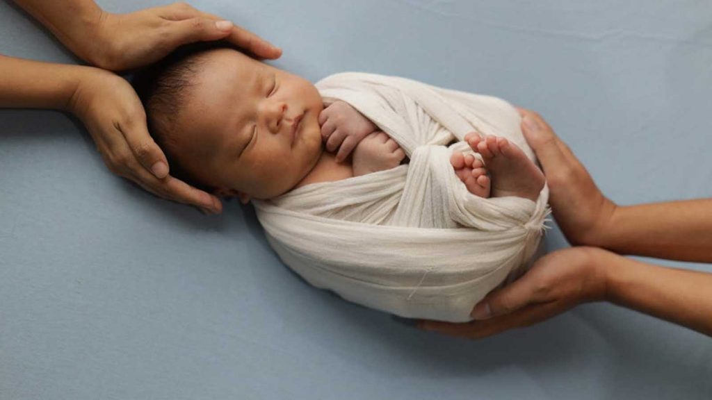 Baby Wearing White Swaddling Blanket