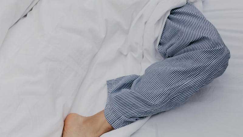 Man Sleeping on Flat Bed Sheets in White